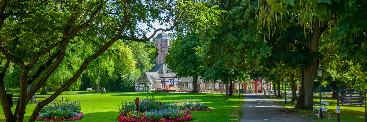 Weg in den Unteren Kurpark mit Blick auf Blumenbeete und im Hintergrund Trinkkurhalle