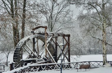 Historisches Wasserrad im Winter schneebedeckt