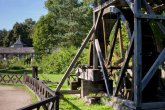 Wasserrad Historisches Wasserrad aus Holz umgeben von Wiesenflächen