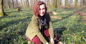 Kräuterführung mit Tanja Adam Kräuterführerin Tanja Adam hockt im Grün und erklärt Kräuter